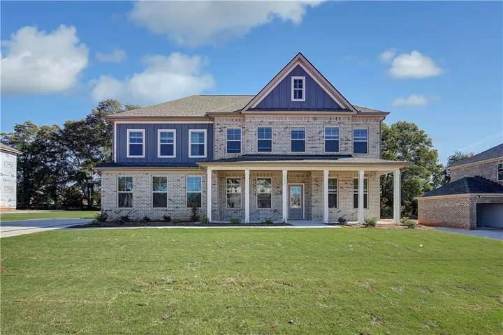 Two-story residence featuring a brick and siding exterior, a covered front porch with white columns, and a prominent gable accent