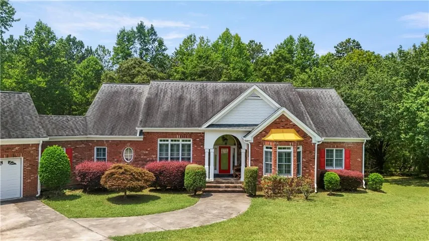 Brick exterior with white trim, a covered entryway, a prominent bay window, and an attached garage