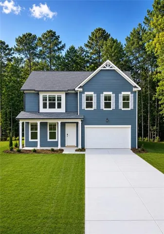 Two-story residence featuring blue siding, white trim, a gabled roofline, and an attached garage with a concrete driveway