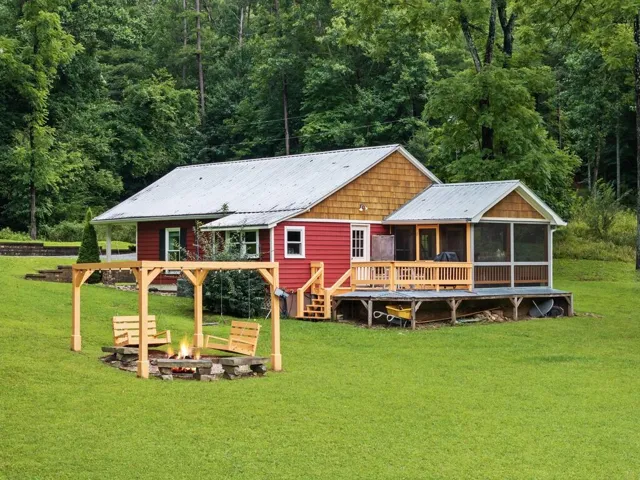 Red siding with wood shingle accents and a metal roof