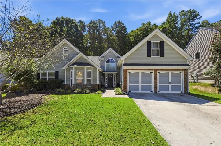Siding exterior with brick accents and a two-car garage
