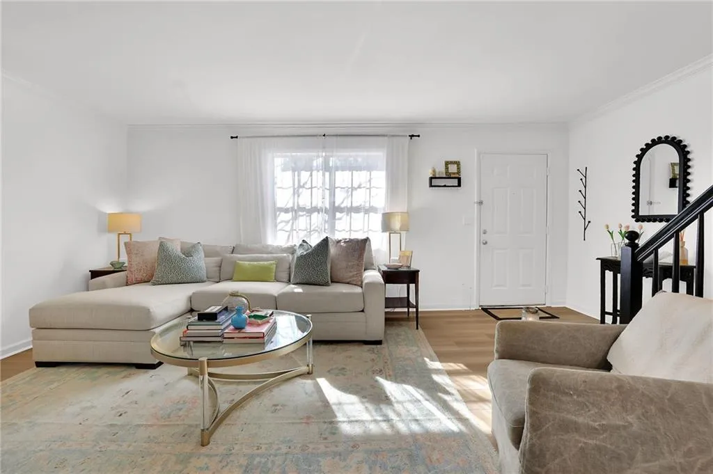 Living room featuring crown molding, wood finished floors, and stairs