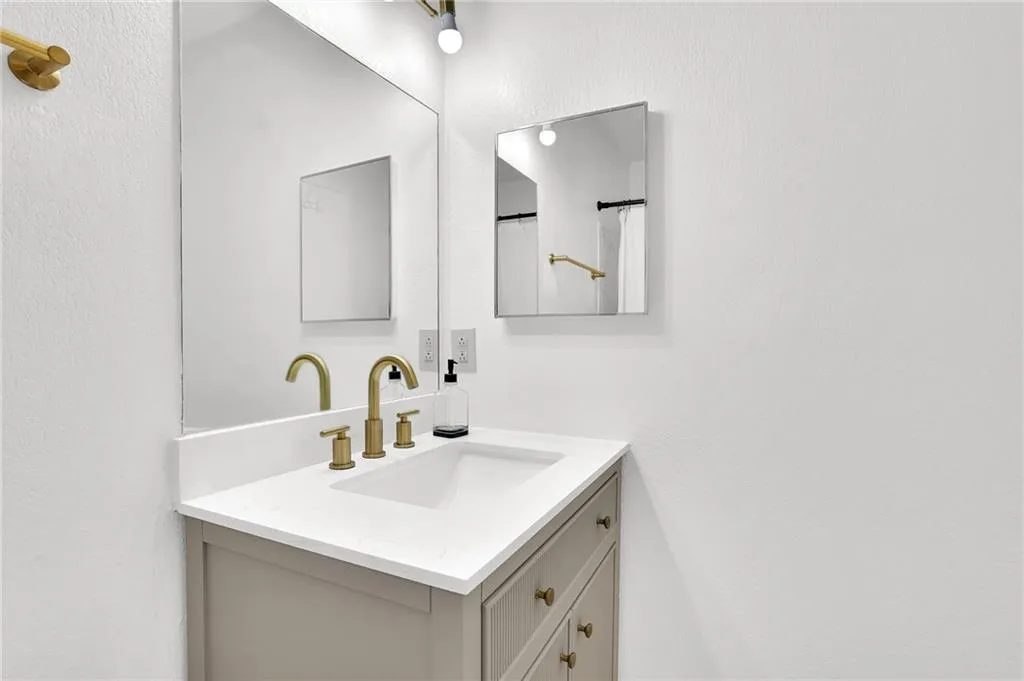 Full bath featuring vanity, a textured wall, and a shower with curtain