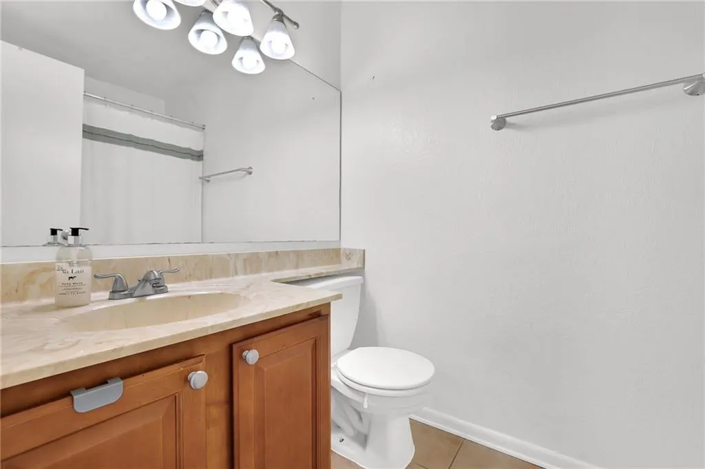 Full bathroom featuring vanity, curtained shower, and light tile patterned floors