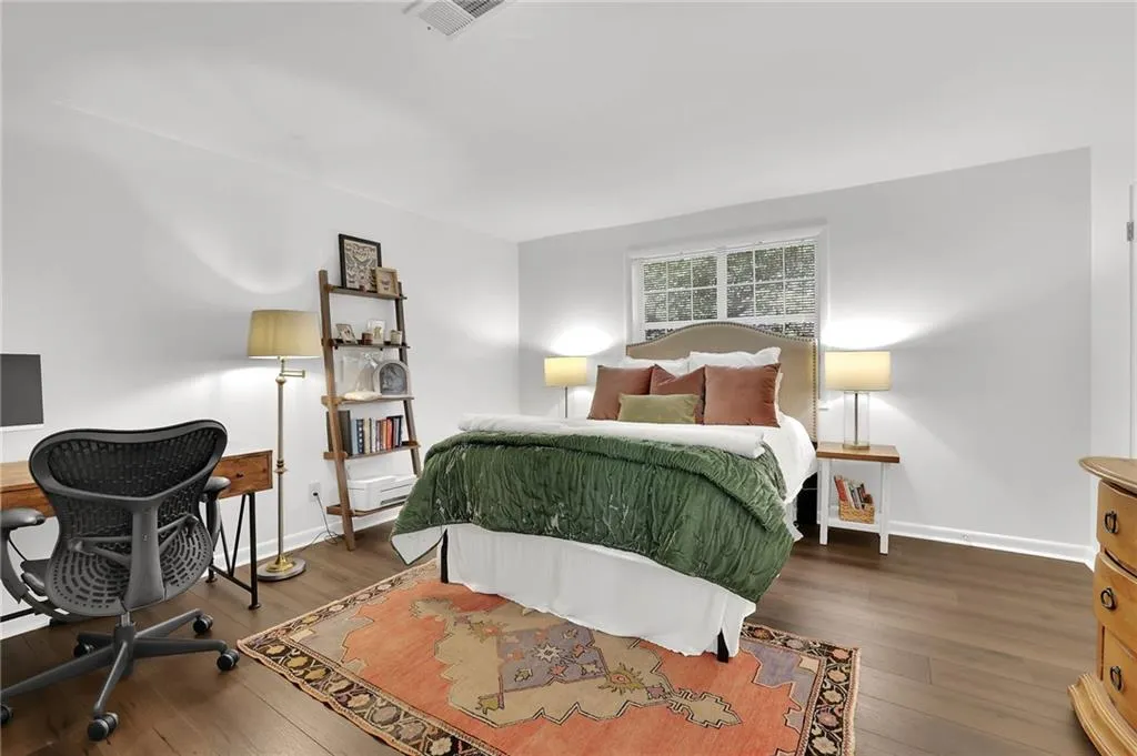Bedroom with hardwood / wood-style flooring and a desk