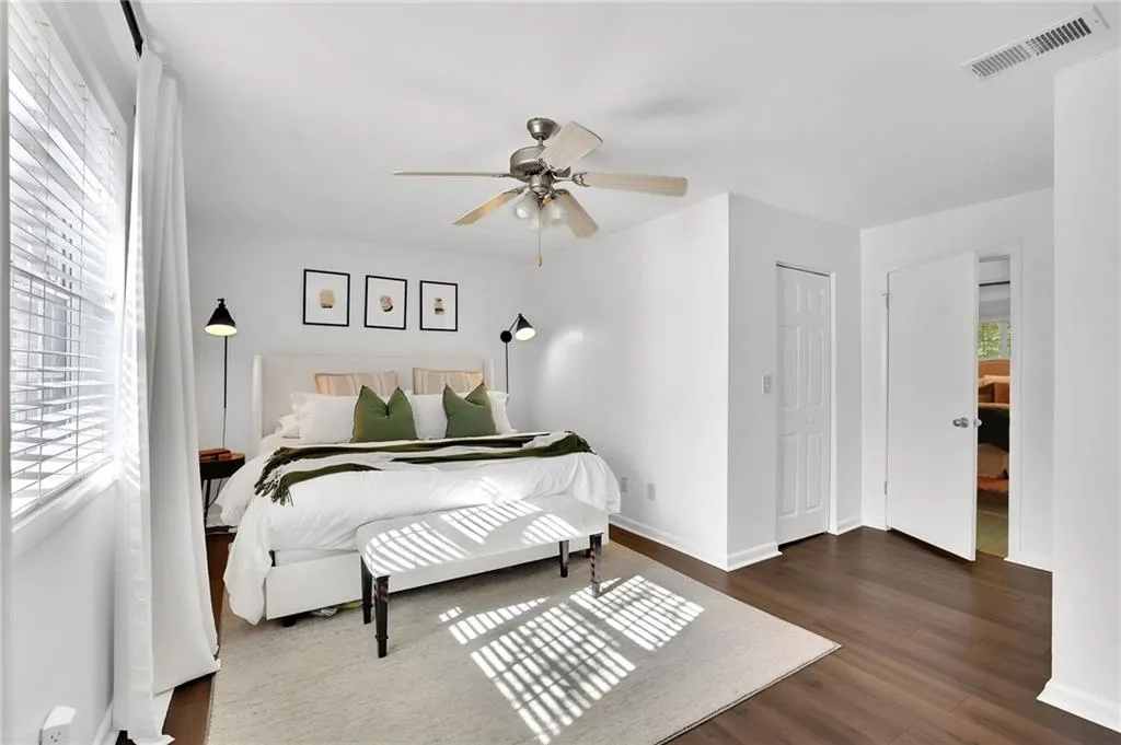 Bedroom with dark wood-style flooring, ceiling fan, and a closet