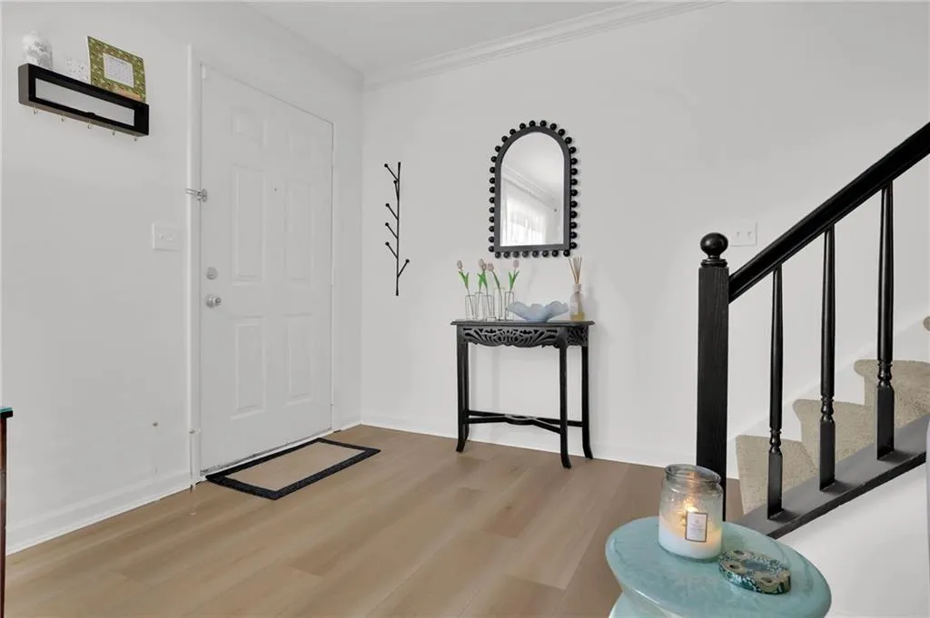 Entrance foyer featuring stairs, light wood finished floors, and ornamental molding