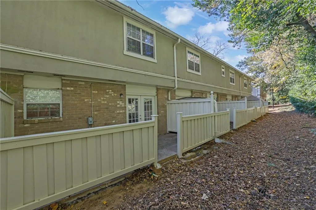 View of property exterior with brick siding, a patio area, and french doors