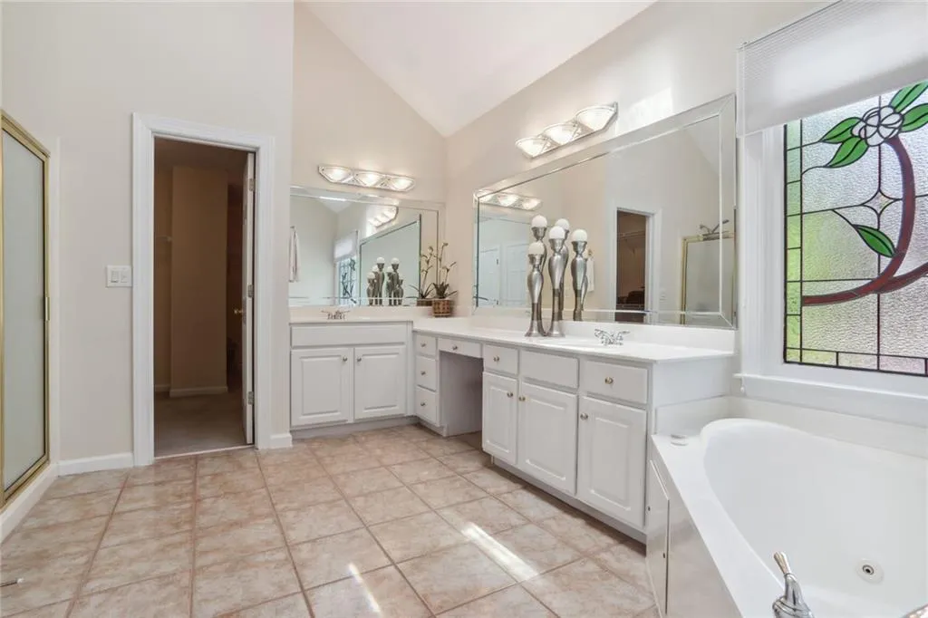 795 Spalding Heights Drive~ Primary Bathroom boasts a whirlpool tub, stained glass, double vanities, separate shower, private toilet, and a large walk- in closet.