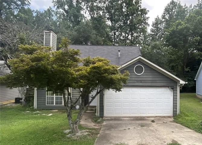 Gray siding exterior with an attached garage, a gabled roofline, and a prominent chimney