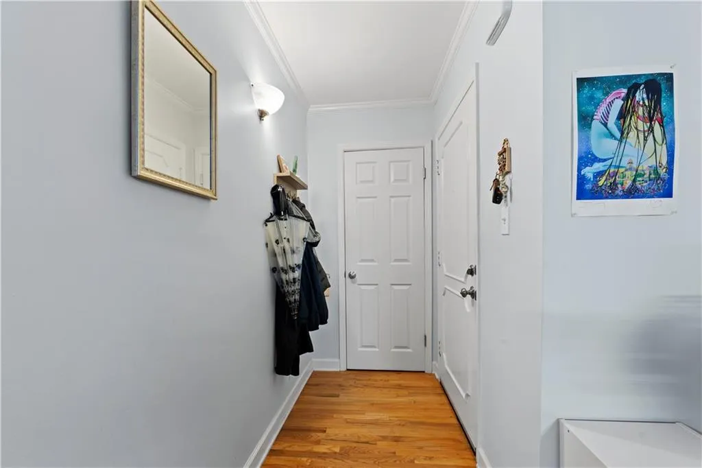 Doorway to outside featuring wood finished floors and ornamental molding
