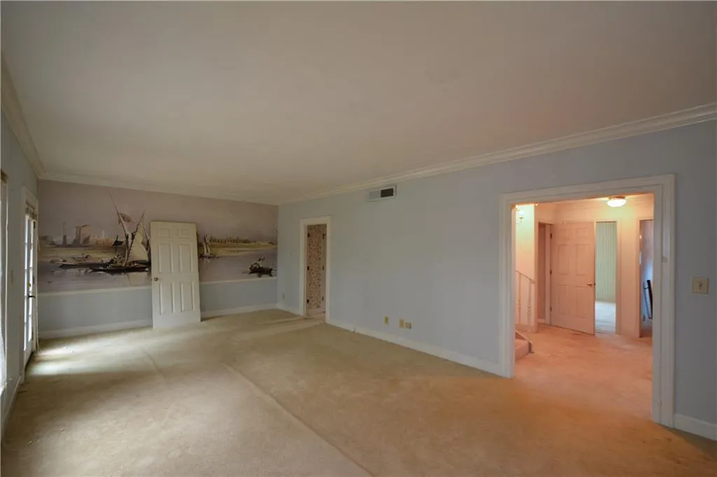 Carpeted spare room featuring ornamental molding