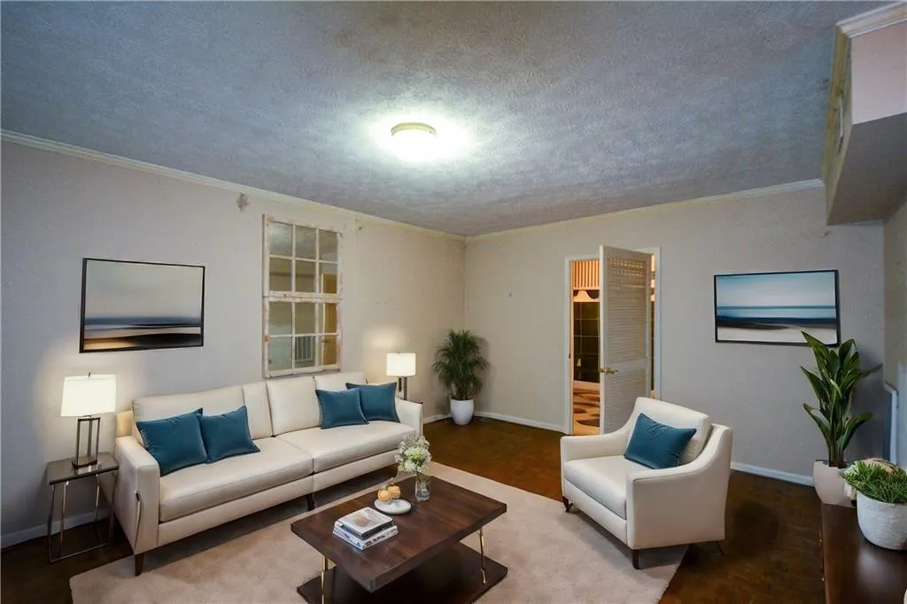 Living room with ornamental molding and a textured ceiling