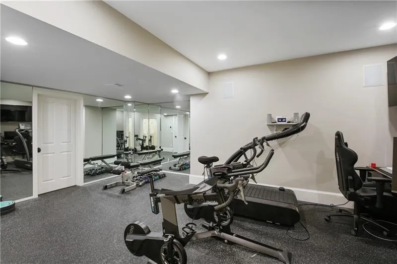 Gym with built in mirrors connected to the bathroom.