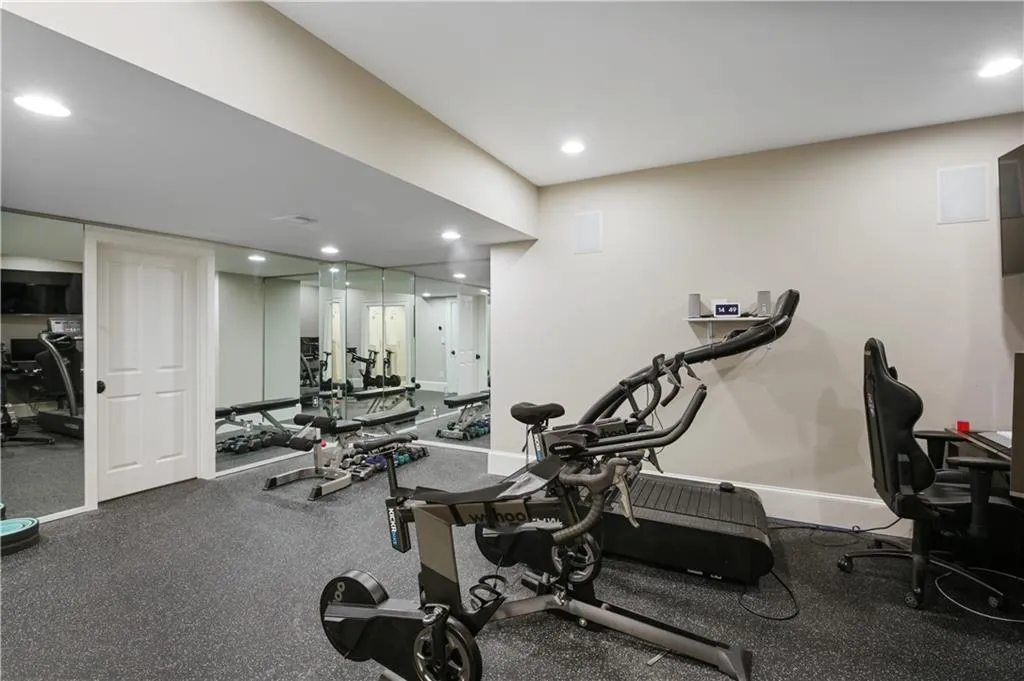 Gym with built in mirrors connected to the bathroom.
