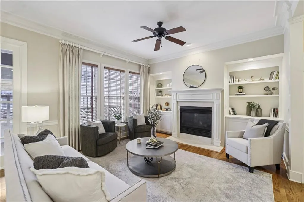 LIving room with built-in bookcases flanking the gas fireplace, and windows with wood blinds