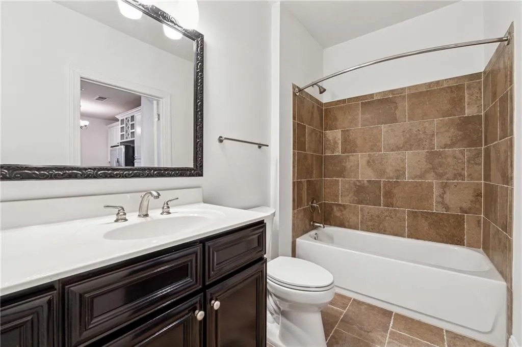 Bathroom with toilet, shower / tub combination, and vanity