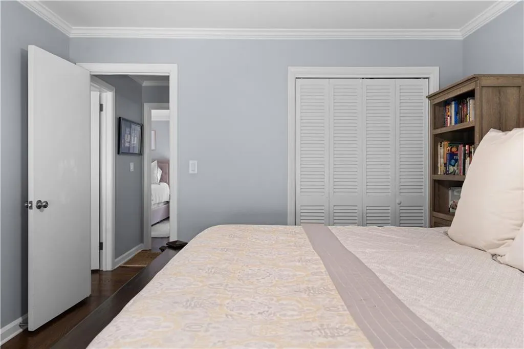 Bedroom featuring dark hardwood / wood-style floors, a closet, and ornamental molding