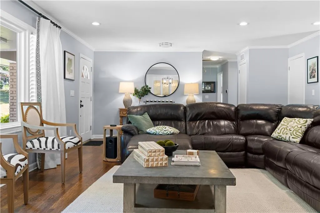 Living room featuring ornamental molding and dark wood-type flooring