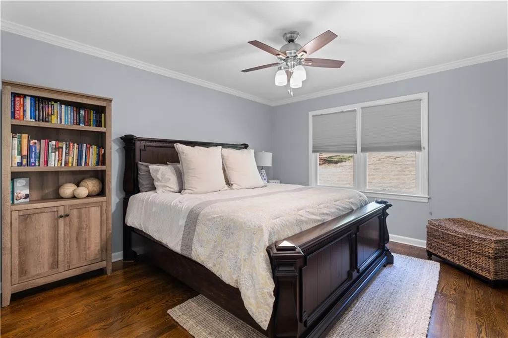 Bedroom with ceiling fan, crown molding, and dark hardwood / wood-style flooring