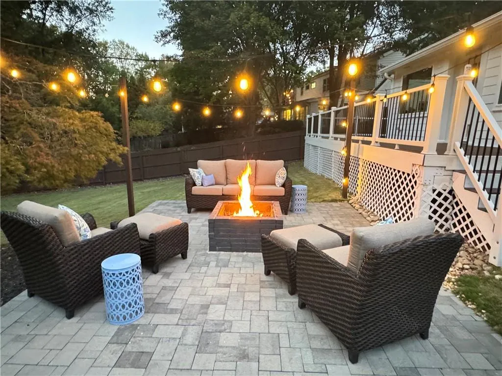 Patio terrace at dusk with an outdoor living space with a fire pit