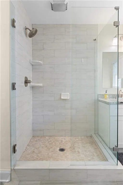 Bathroom featuring vanity and a shower with shower door