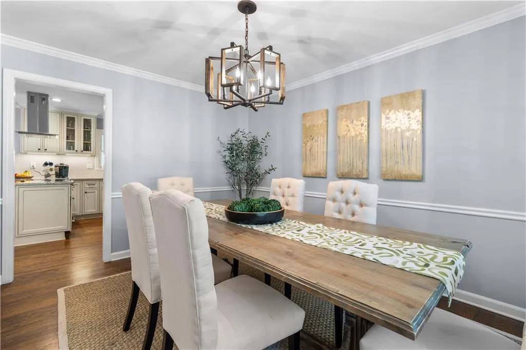 Dining area featuring a notable chandelier, dark hardwood / wood-style floors, and crown molding