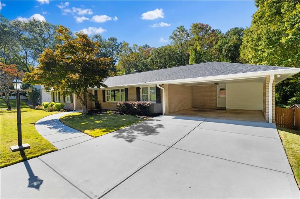 Ranch-style house featuring a front lawn and a carport