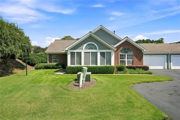 Exterior with brick and siding facade, arched windows, covered entry, and attached garages
