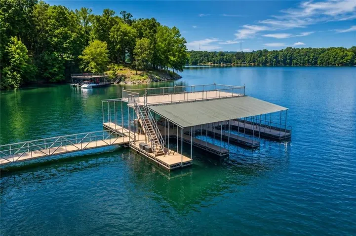 Two-story dock with covered boat slips, an upper sun deck, and a gangway connecting to the shore