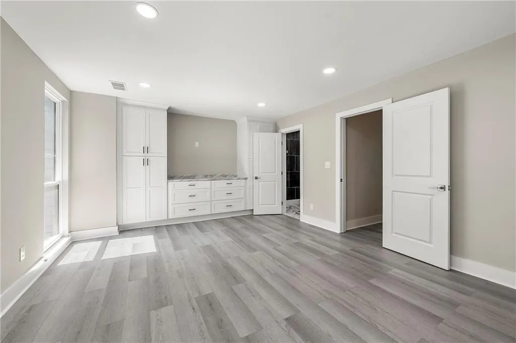 Primary bedroom with view of custom closets