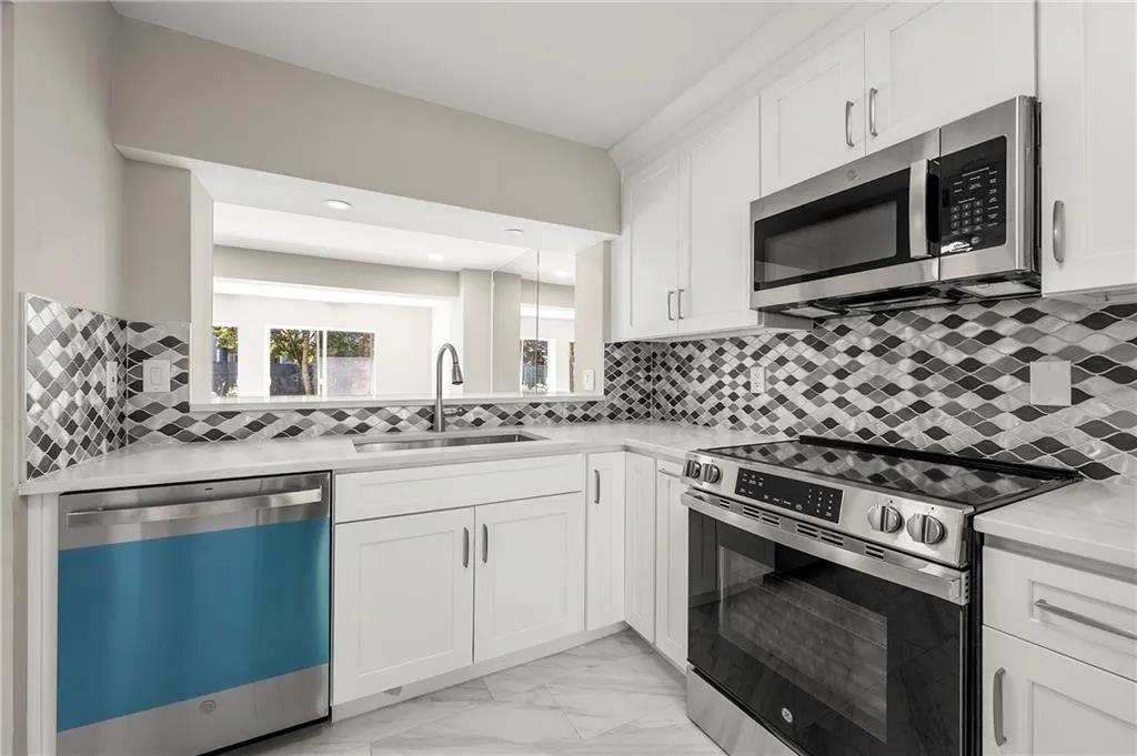 Stainless steel dishwasher, tiled floor, new black and stainless microwave floor, quartz counter top and new stainless  sink and faucet.