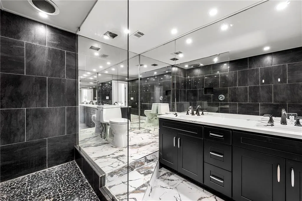 Elegant primary bathroom with new vanities including soft close drawers and doors, new faucets and new toilet.