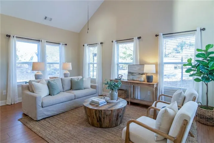Living room with wood finished floors and high vaulted ceiling