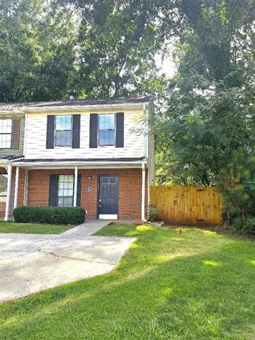 Two-story residence featuring a brick facade on the lower level and siding on the upper level, complete with dark shutters