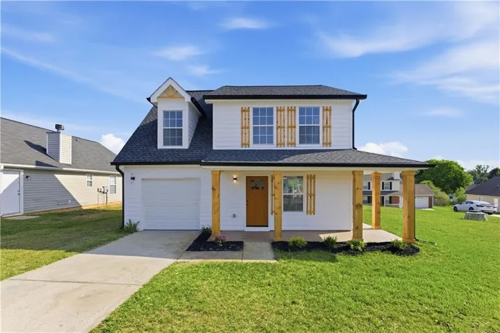 Two-story exterior with white siding, covered front porch with natural wood posts, and an attached single-car garage