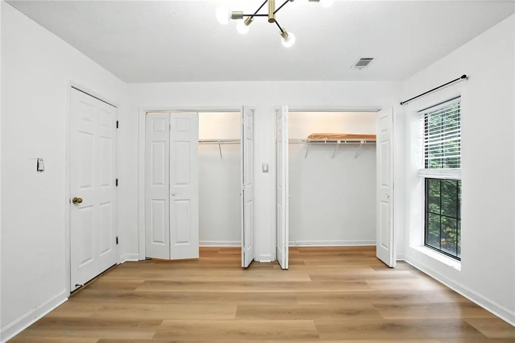 Unfurnished bedroom featuring multiple closets and light wood-type flooring