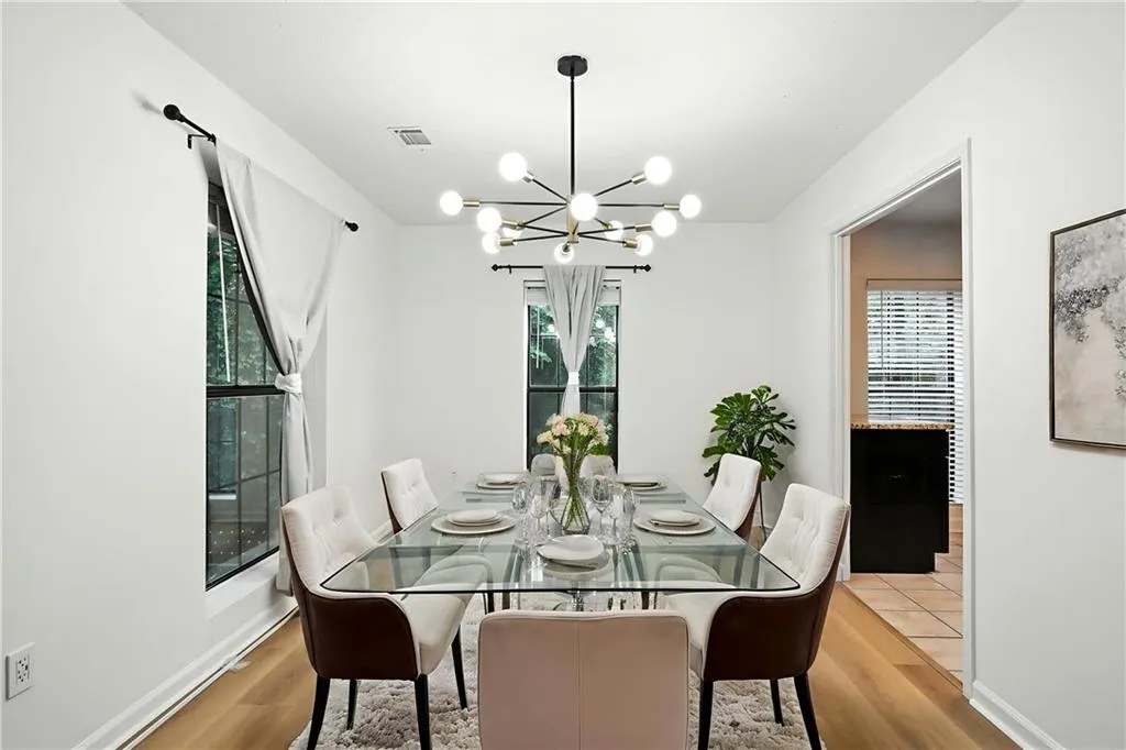 Dining area with a chandelier, light wood-type flooring, and plenty of natural light