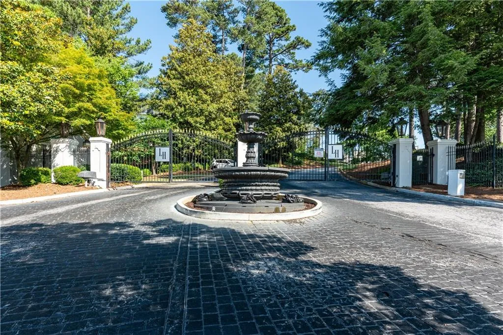 View of road featuring a gate, a gated entry, and curbs