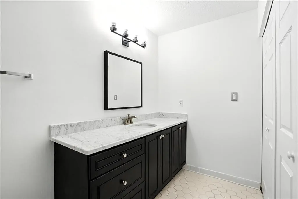 Bathroom with vanity, tile patterned flooring, and a textured ceiling
