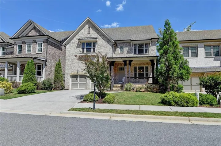 View of front of property featuring covered porch, brick siding, driveway, and a front yard