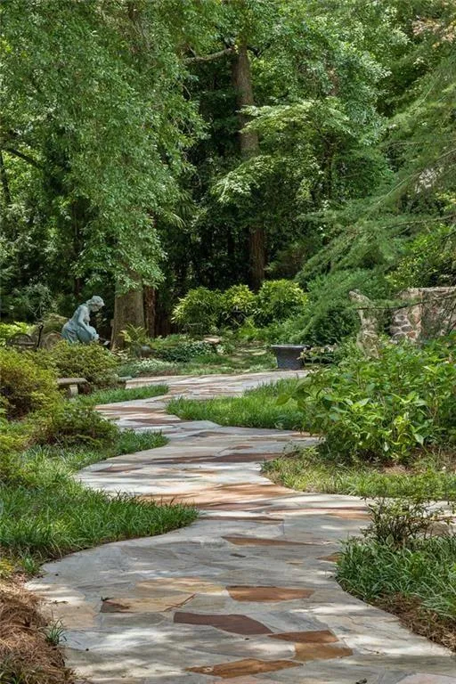 Elegant garden statuary lines the pathway, adding a touch of old-world artistry to the grounds.
