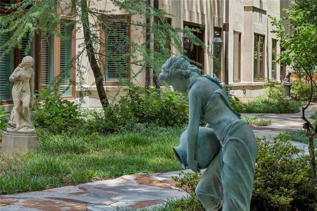 Elegant garden statuary lines the pathway, adding a touch of old-world artistry to the grounds.