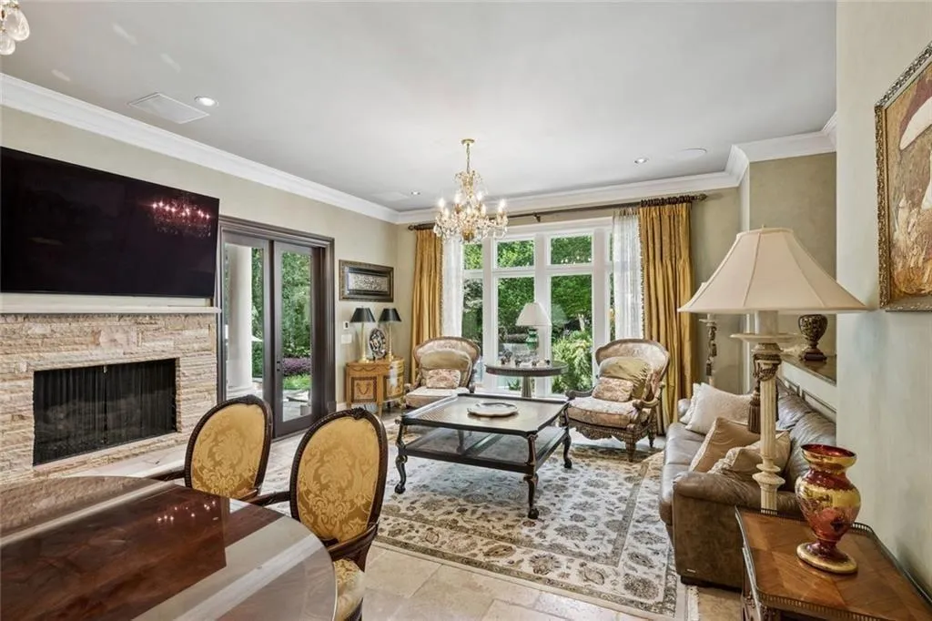 The family room flows seamlessly between cozy fireside seating and breakfast dining, with floor-to-ceiling windows flooding the space with natural light.