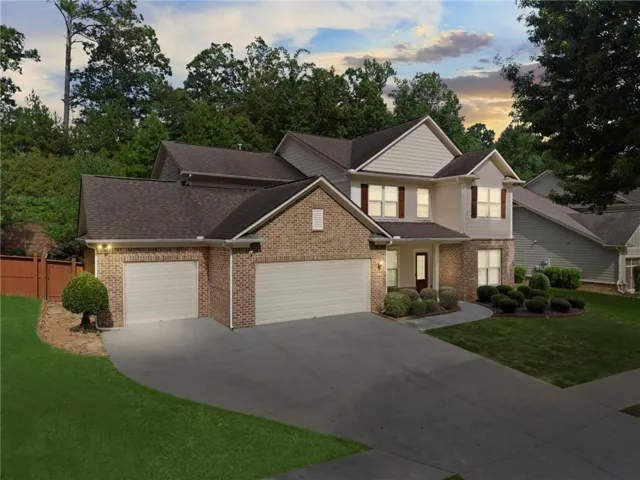 Two-story residence featuring a brick and siding exterior with dark shutters