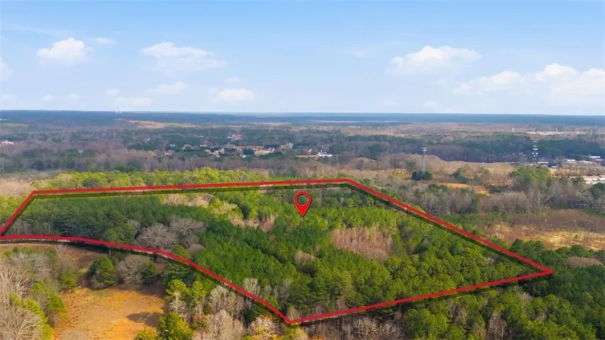 Expansive parcel of land featuring mature trees and varied foliage