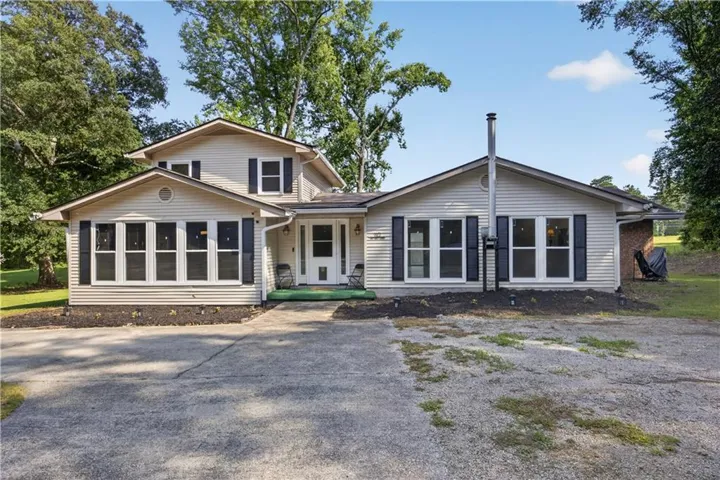 Traditional-style residence featuring light-colored siding and dark shutters