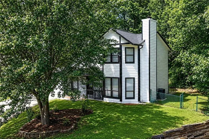 Two-story residence featuring white siding and black trim accents