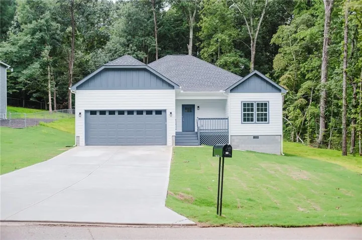 Single-story residence featuring a gray garage door, white siding, and a contrasting gray front door