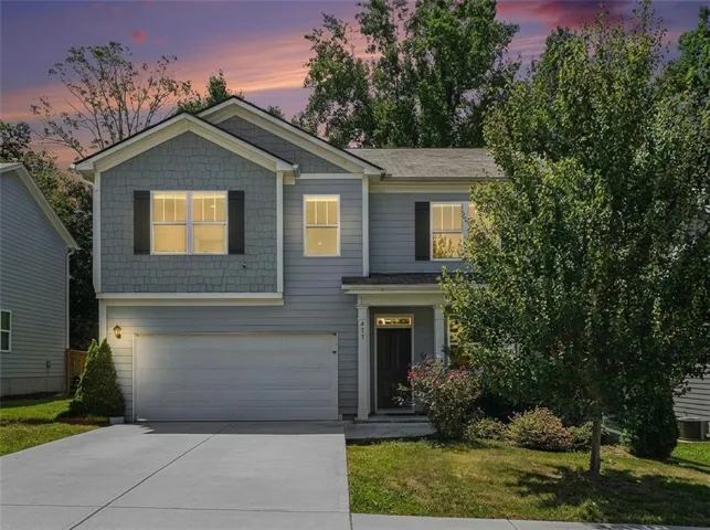 Two-story exterior with a gabled roofline, mixed siding, attached garage, and a concrete driveway